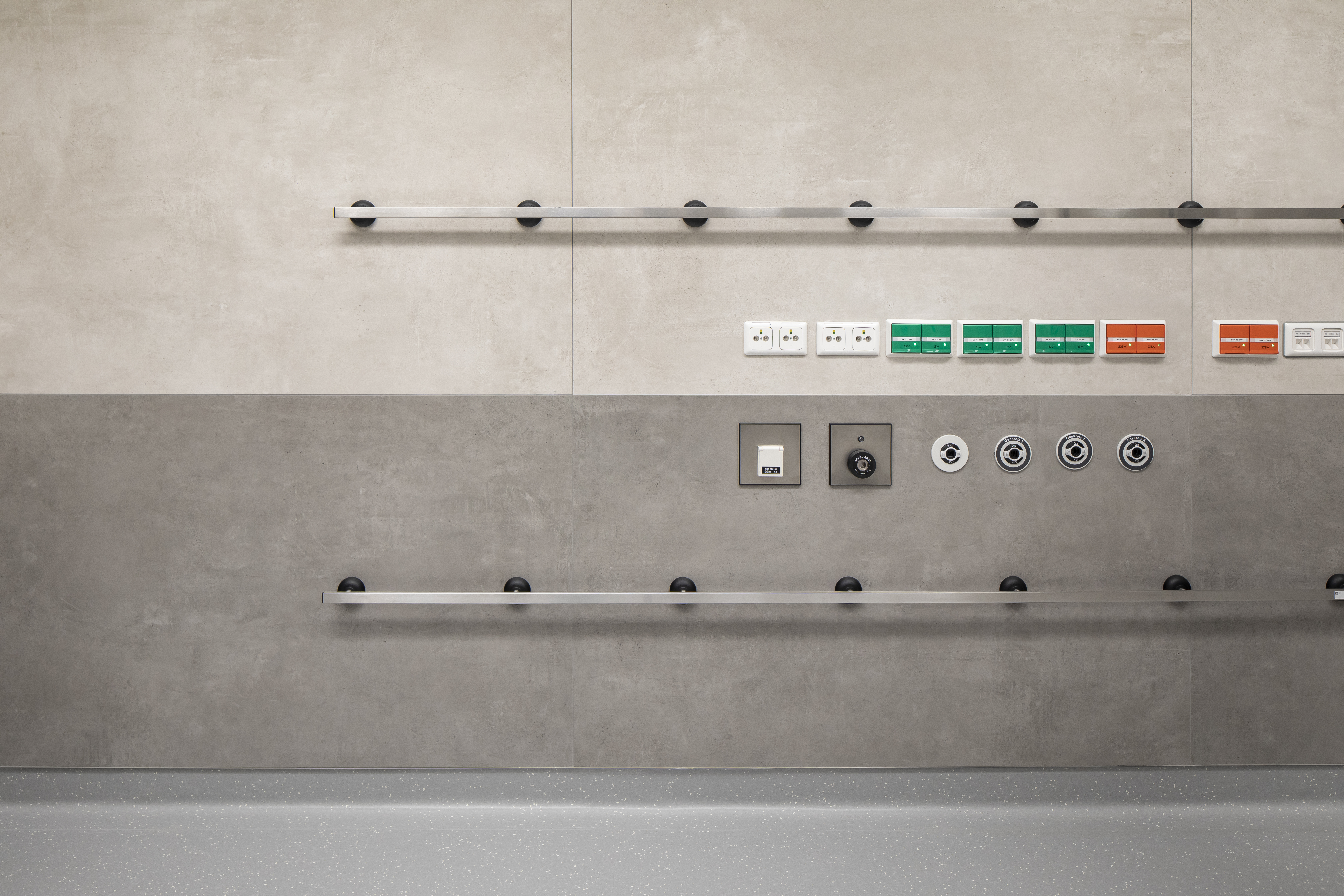 Two-tone wall tiles in light and dark grey with concrete effect.