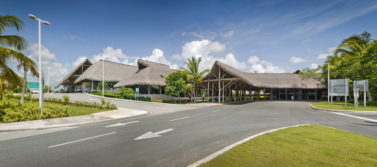 Exotic entrance area with thatched roofs and palms, ideal for outdoor tiles.