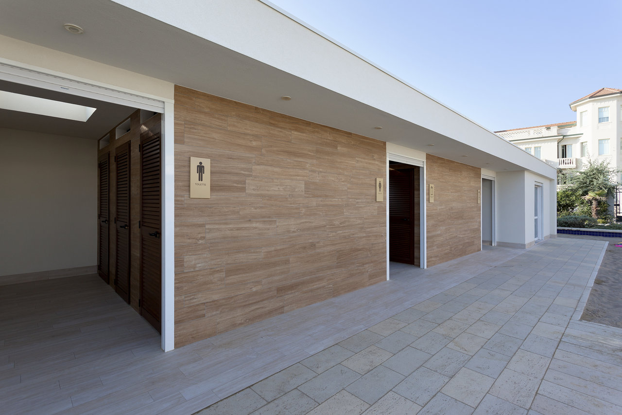 Wood-look facade tiles and light outdoor floor tiles on a modern building.
