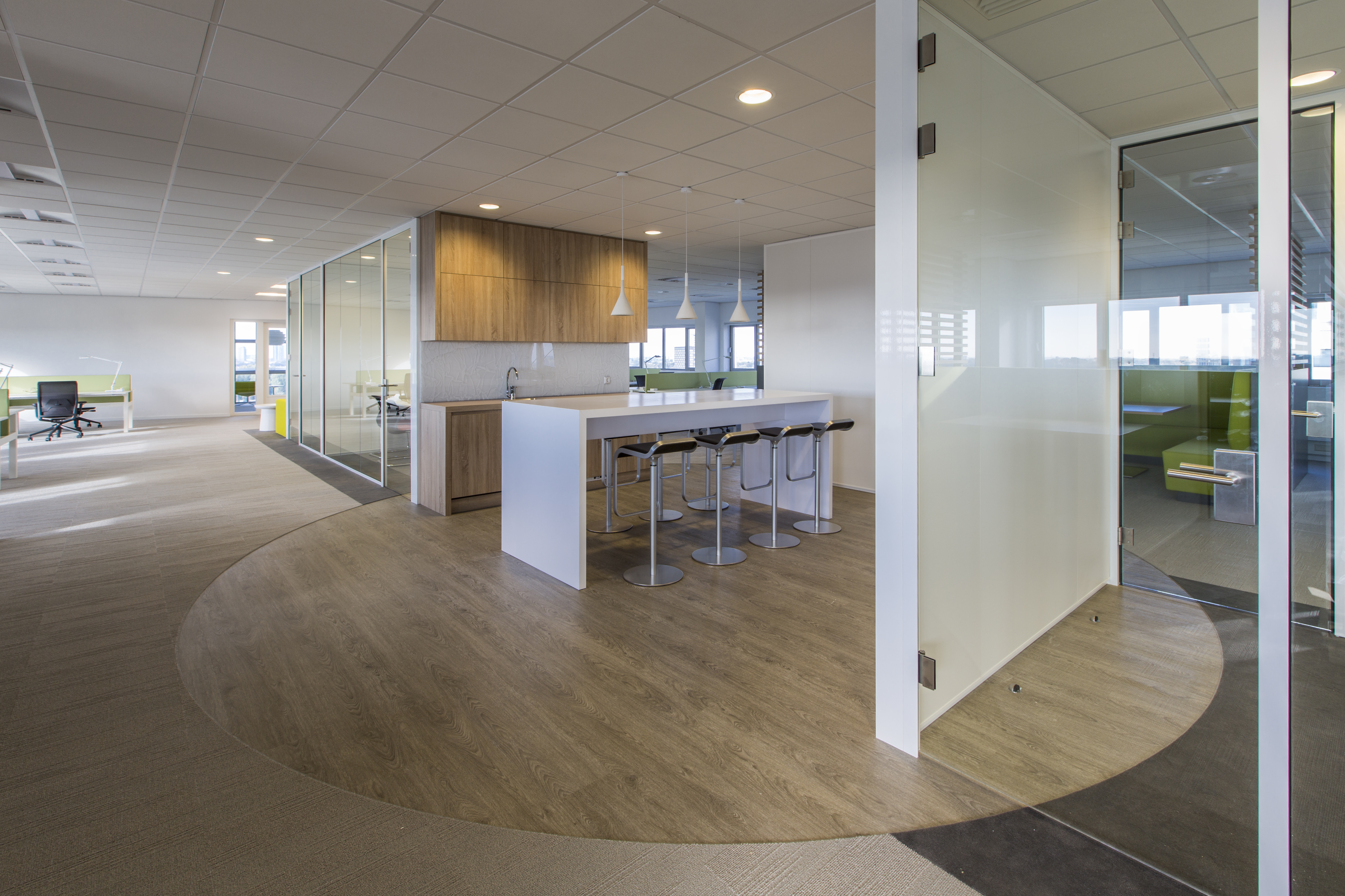 Modern office space with light wood-look tiled floor and bar.