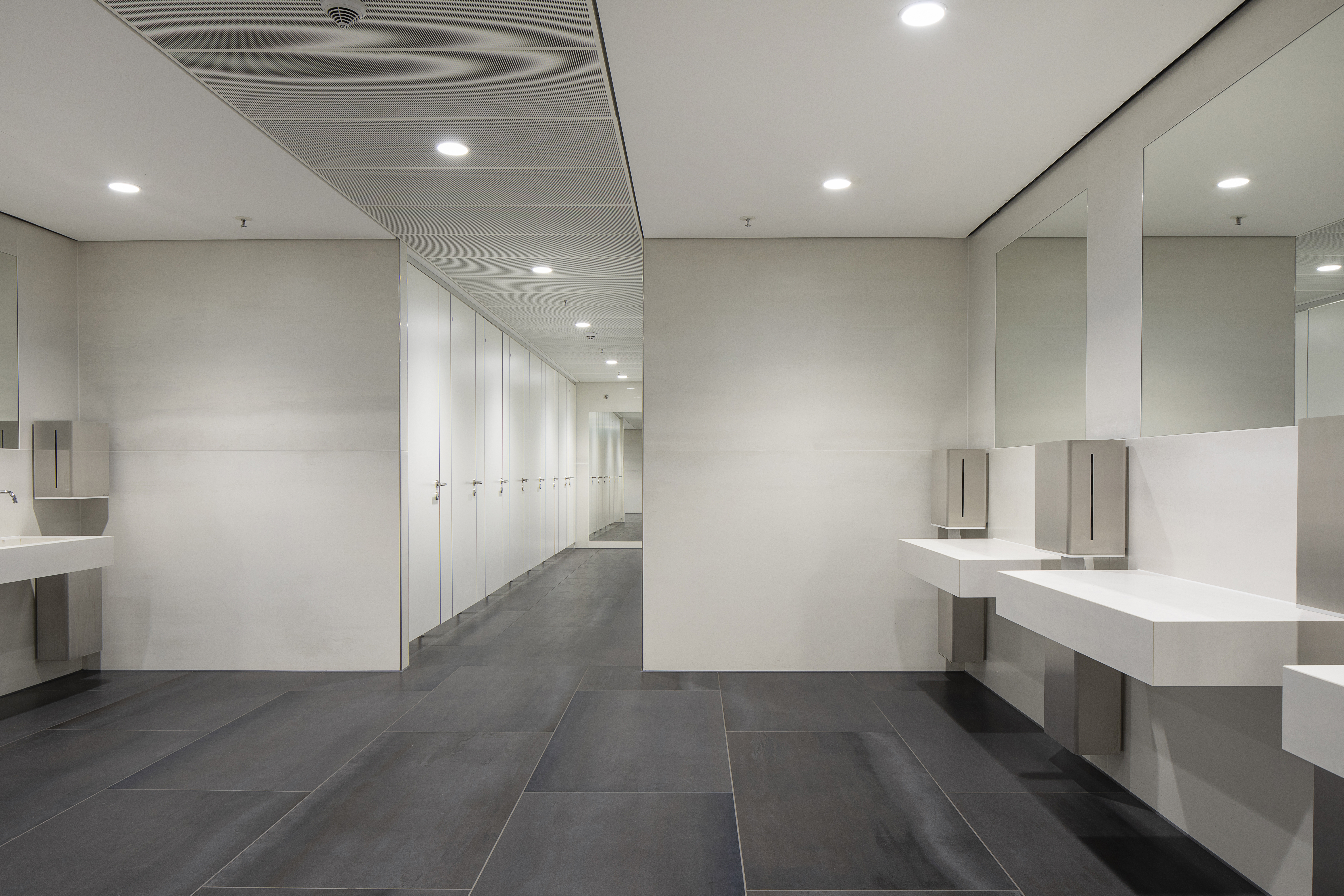 High-quality dark grey large-format floor tiles in a modern washroom.