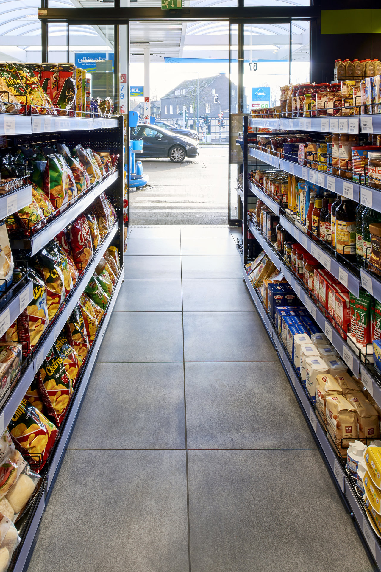 Modern shop aisle with robust, large-format grey floor tiles, showcasing quality and functionality.