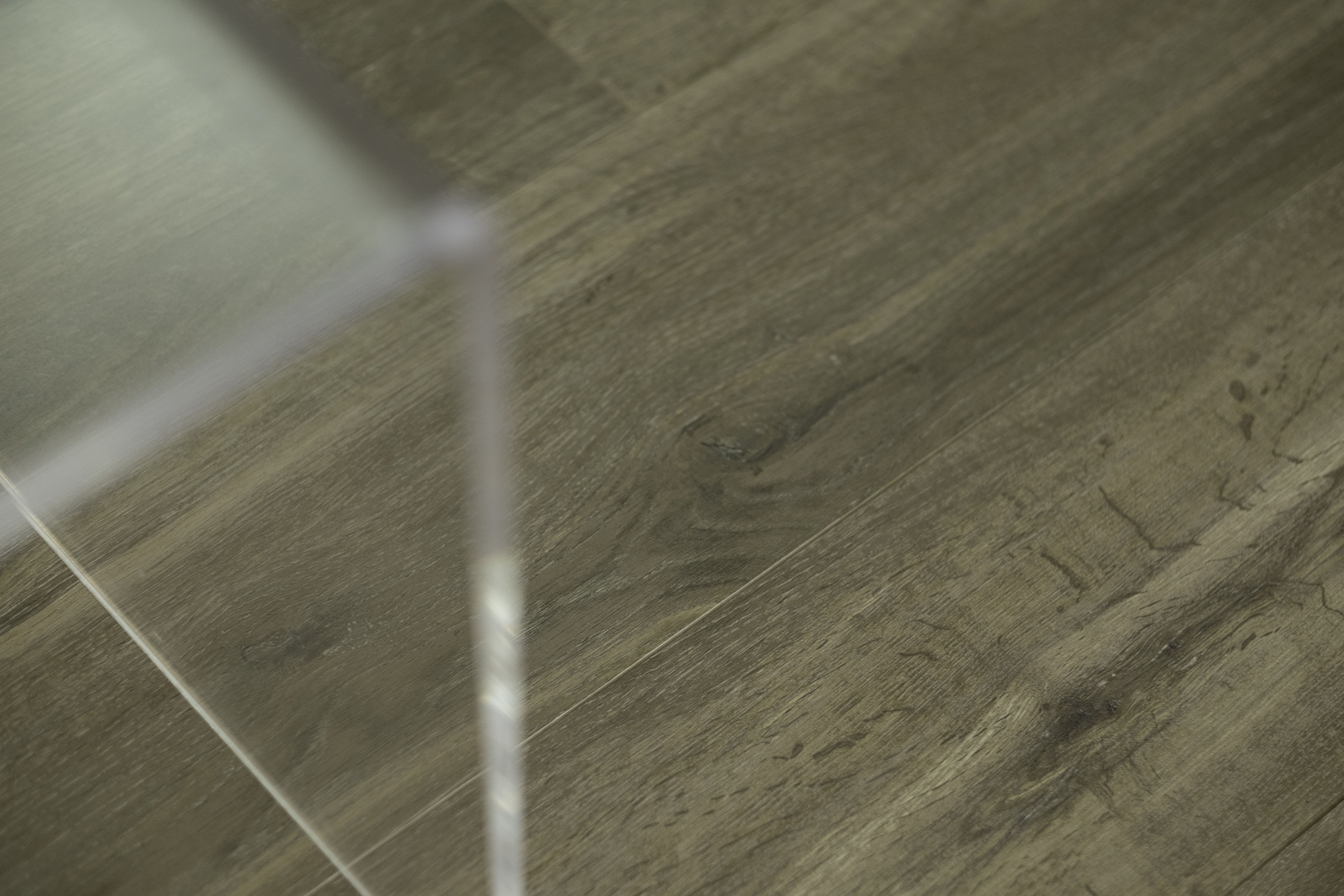 High-quality wood-look tiles with natural grain in dark grey-brown.