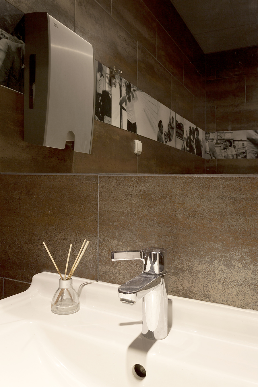 Warm brown wall tiles in a stylish bathroom with a washbasin and decoration.