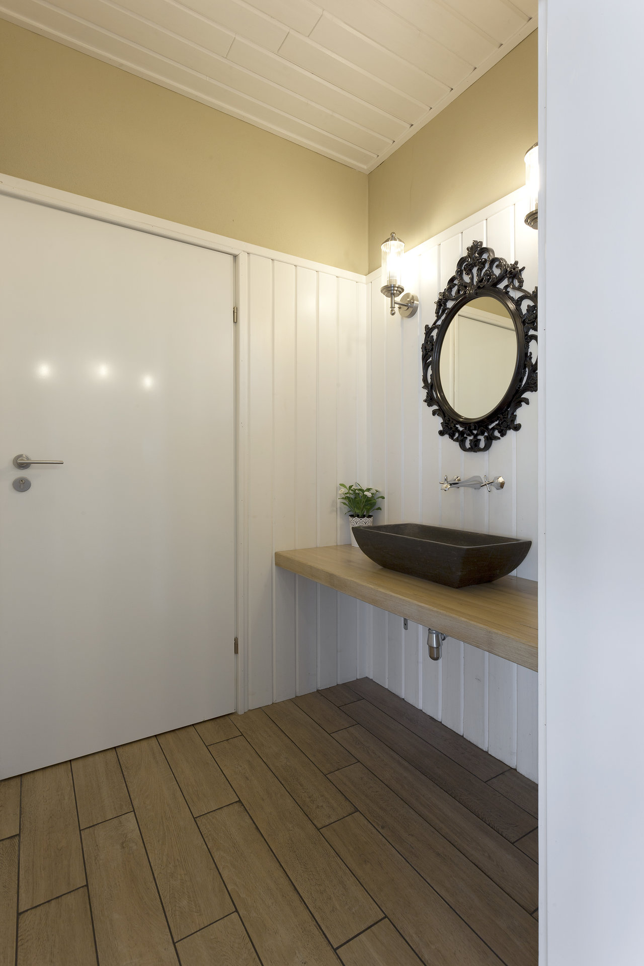 Porcelain wood-effect tiles in bathroom, with washbasin and mirror.