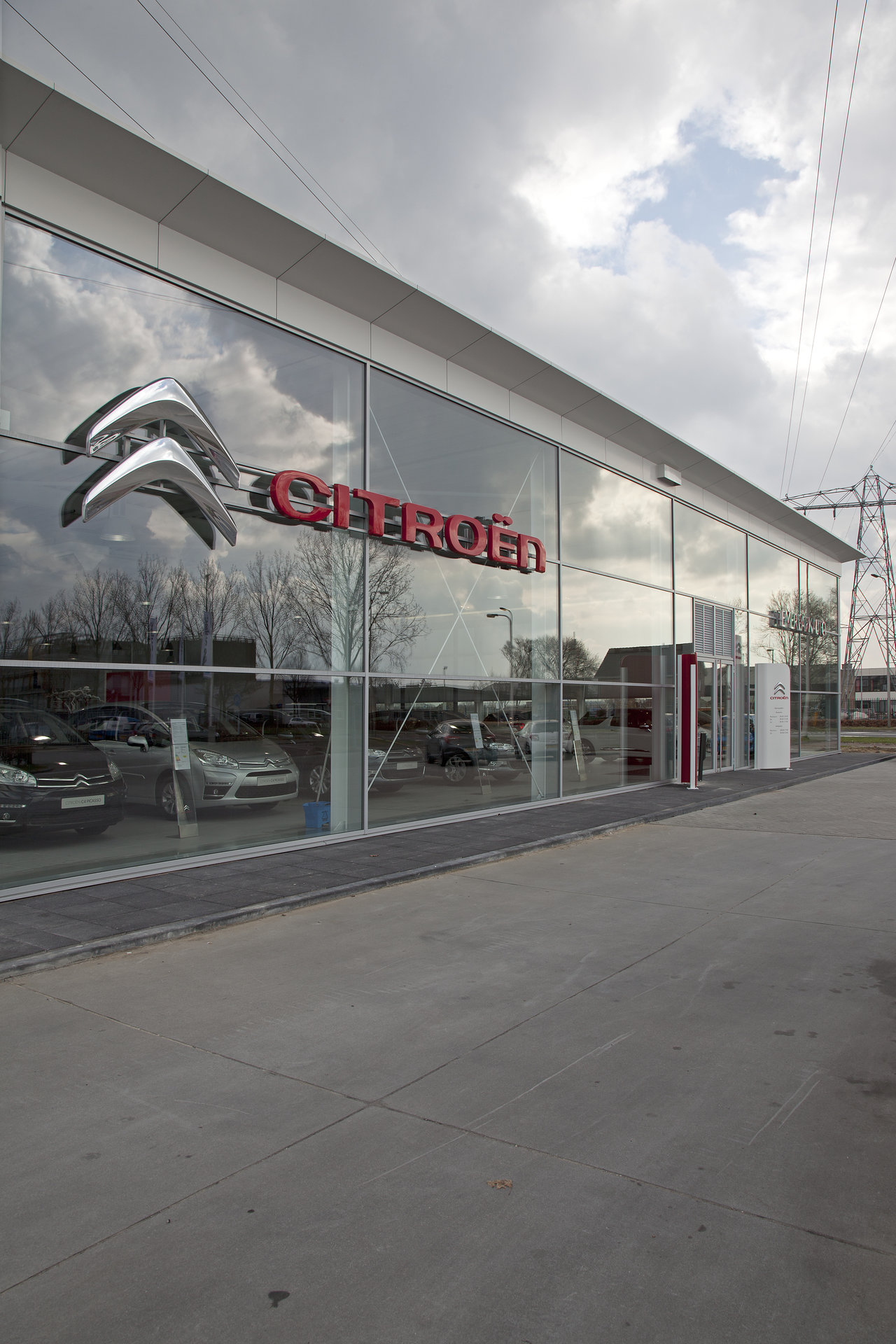 Large concrete forecourt before a modern building with glass facade.