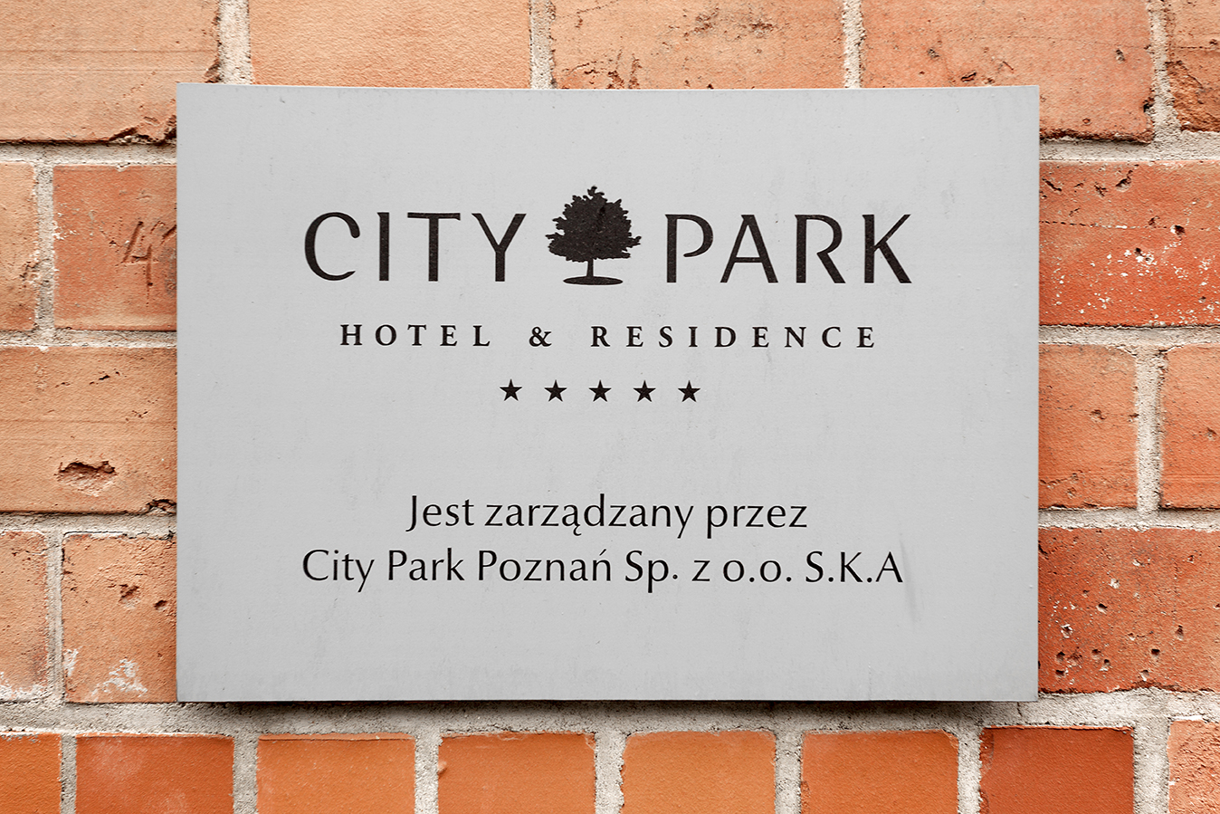 'CITY PARK HOTEL & RESIDENCE' sign on a brick wall.