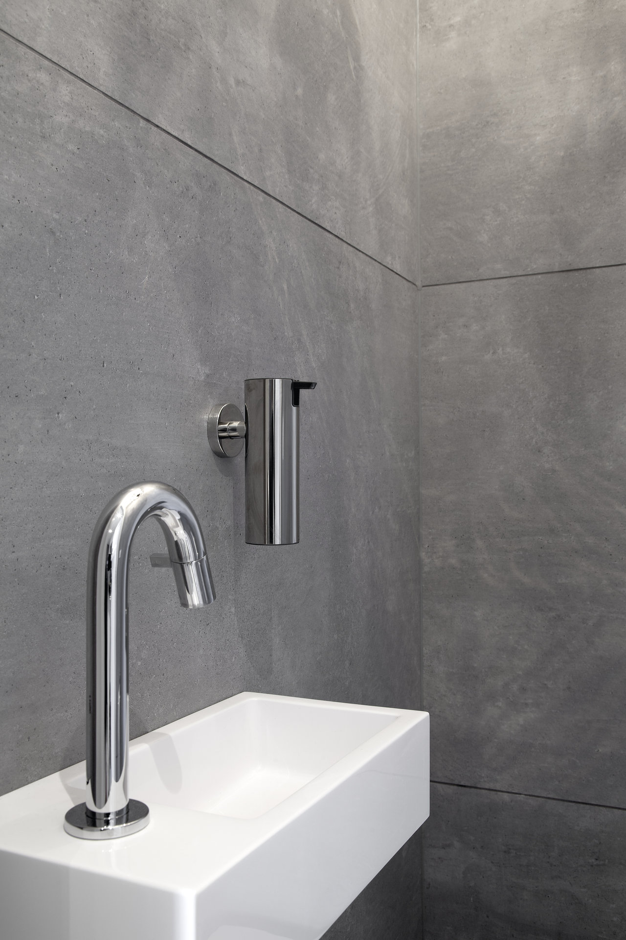 High-quality grey concrete-effect tiles for a modern bathroom with washbasin.