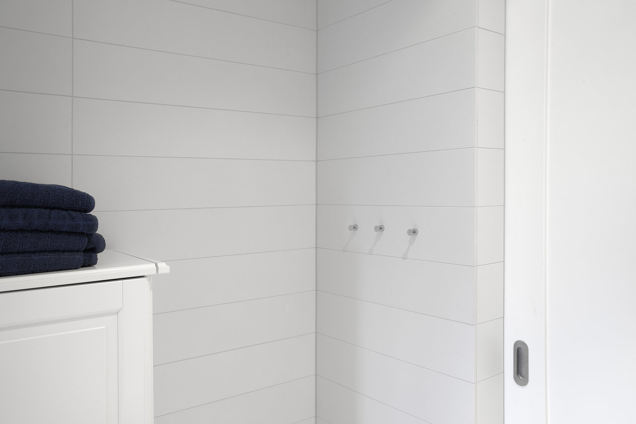 Bright, large-format bathroom wall tiles, horizontally laid.