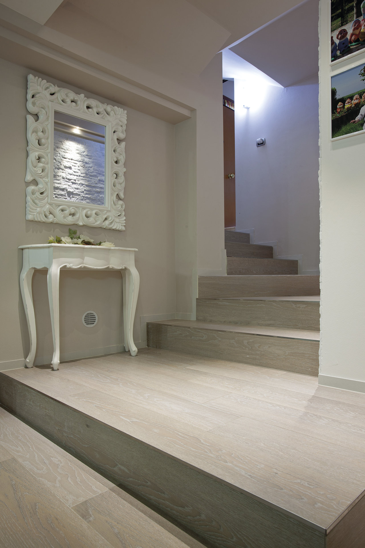Light wood-effect tiles on floor and stairs in an elegant entrance area.