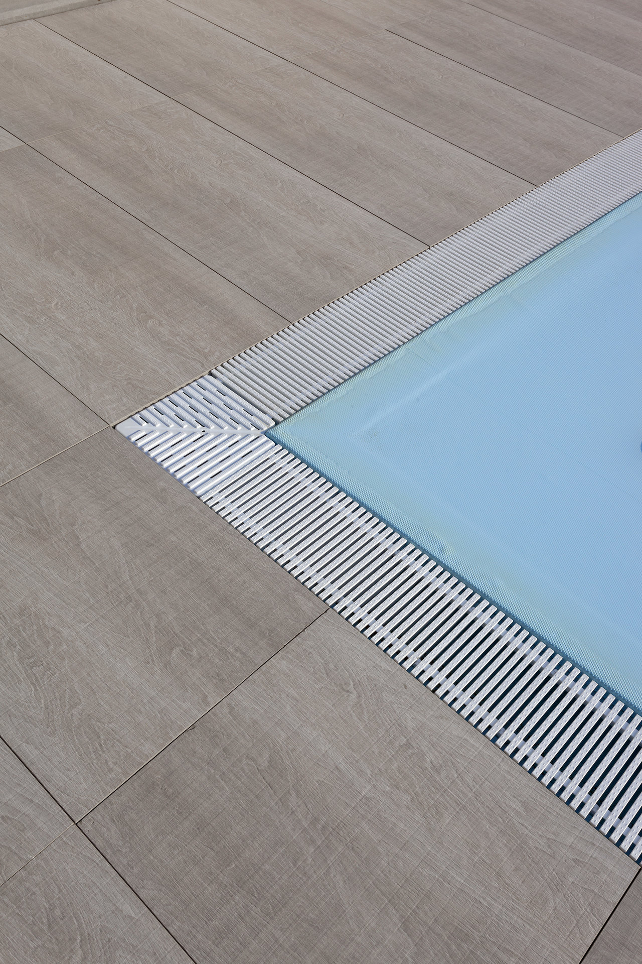 Modern outdoor pool edge tiles with overflow channel.