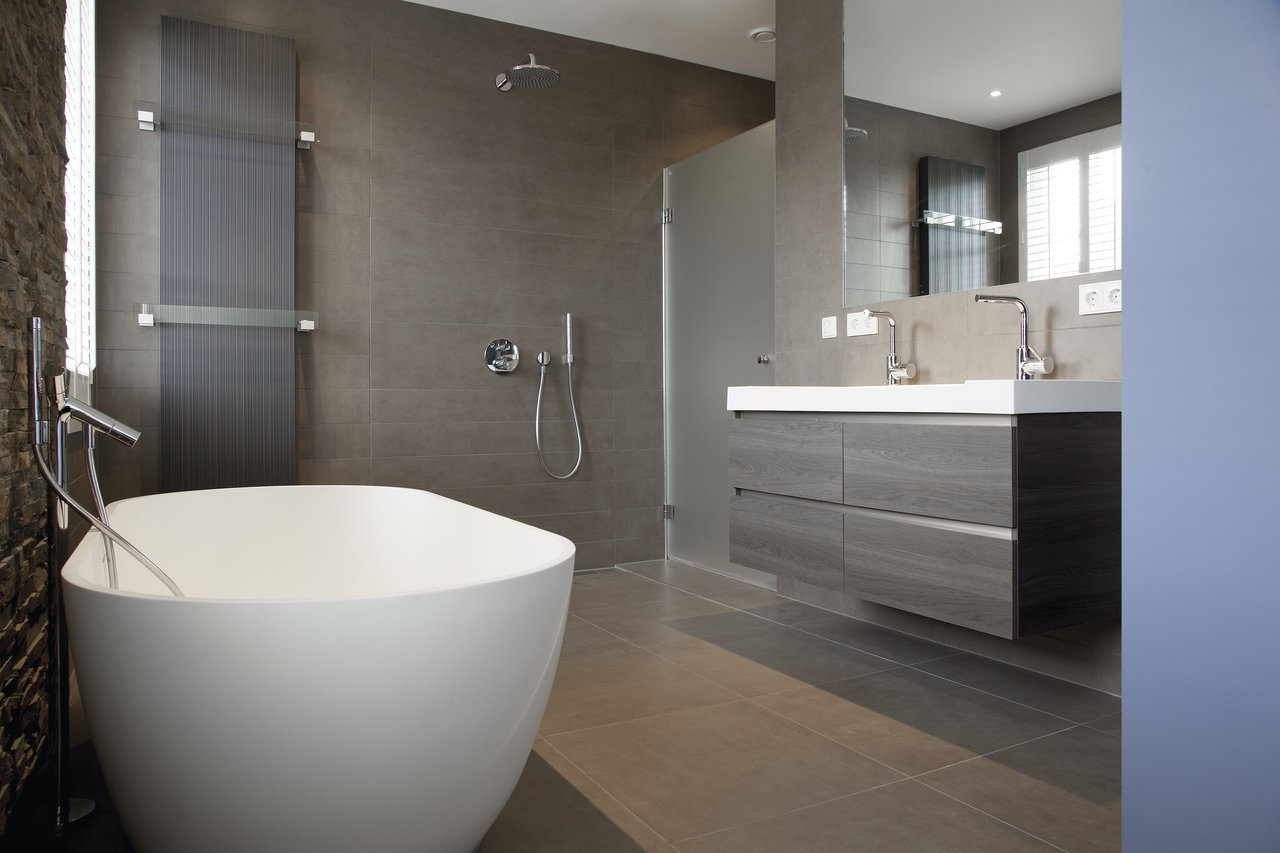 Modern bathroom with high-quality, large-format grey tiles on walls and floor.