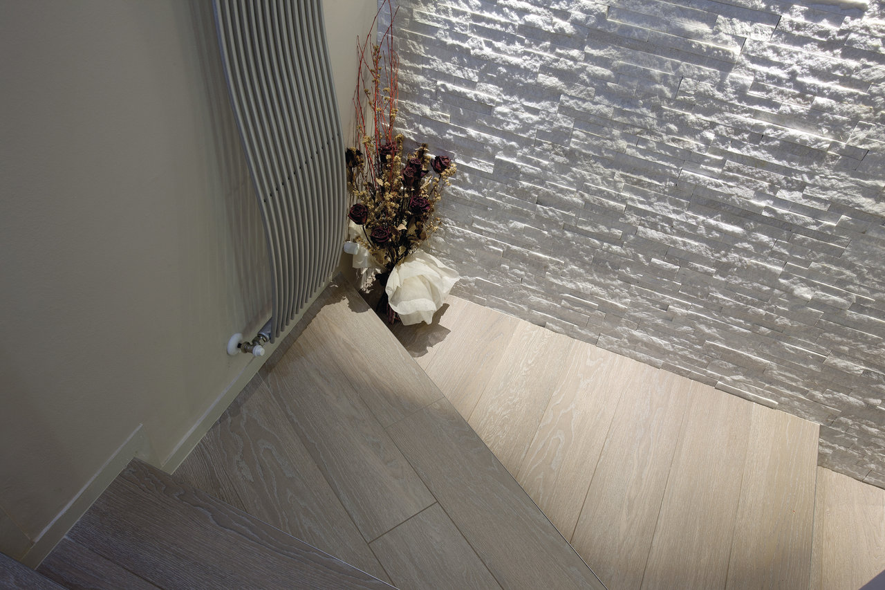 Light wood-look floor tiles and white stone-look wall tiles.