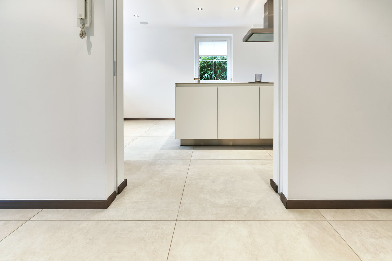 Light, large-format floor tiles in a modern interior.