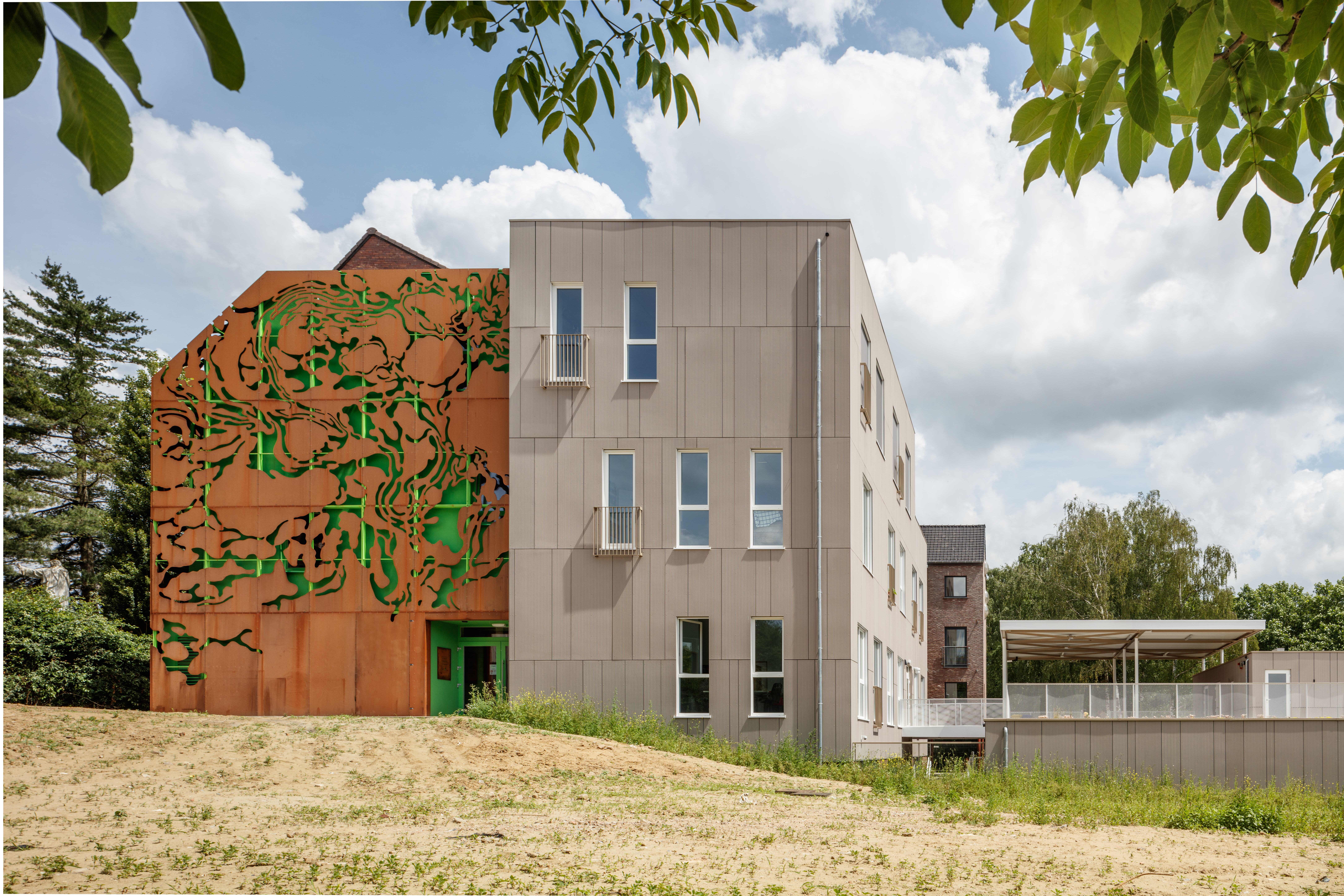 Modern architecture with a striking rust-look facade and plain grey surfaces.