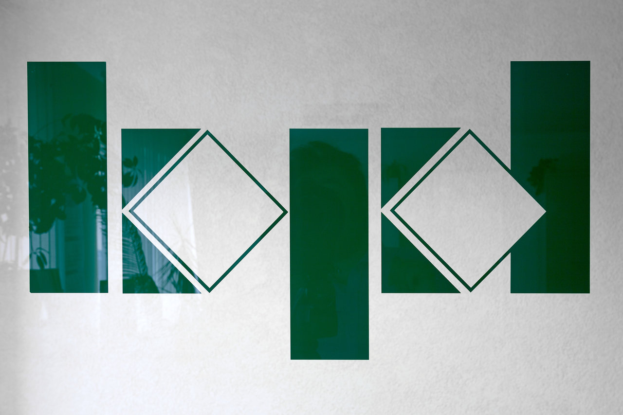Abstract, glossy green rectangle and diamond pattern on light background.