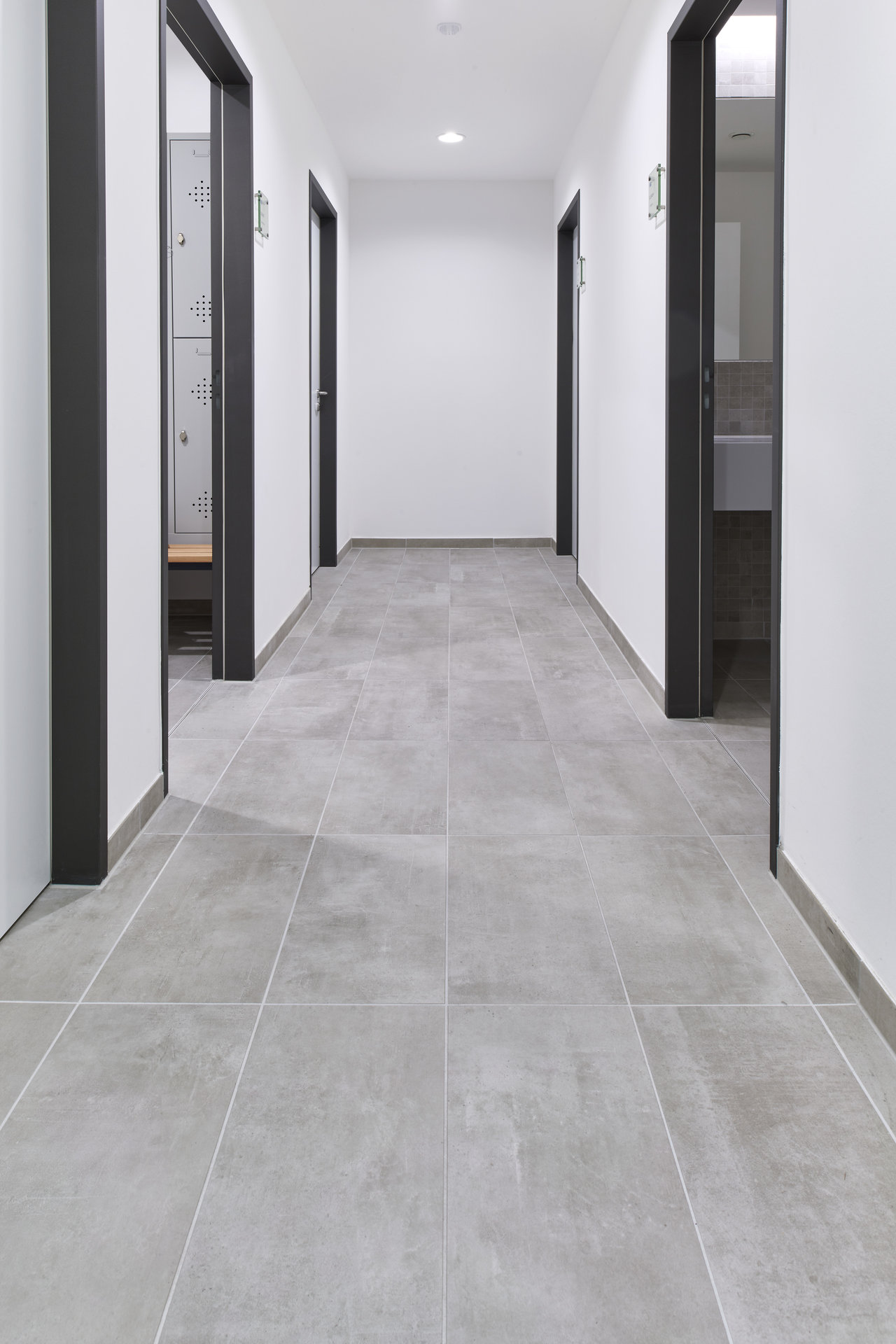 Bright hallway with modern, large-format grey tiles.