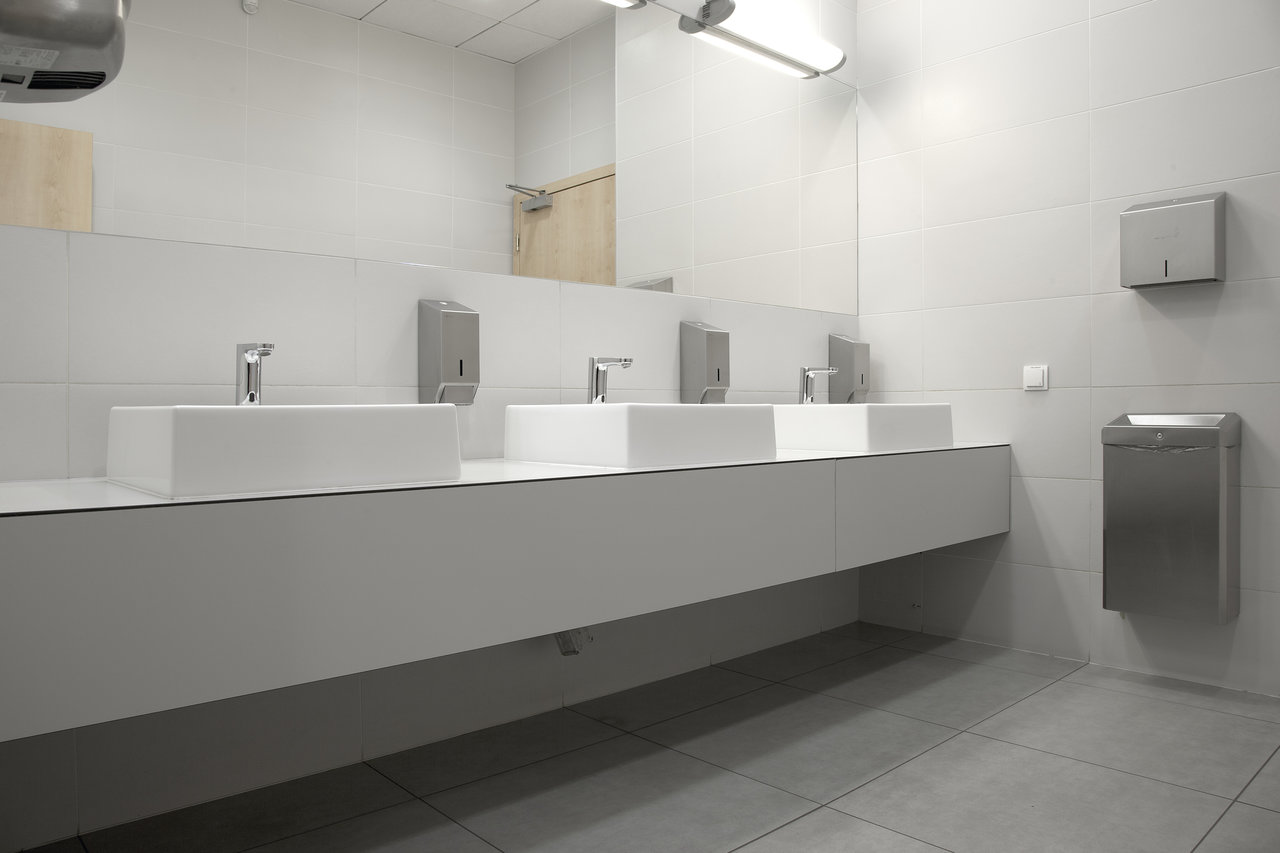Bright, modern washroom with grey wall and floor tiles.