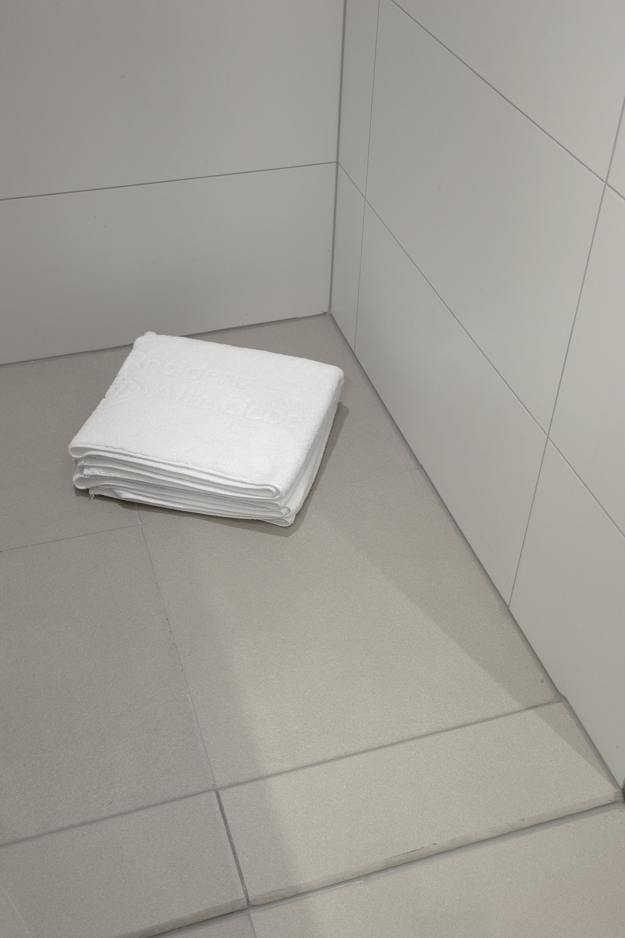 High-quality light grey floor tiles and white wall tiles in modern design.
