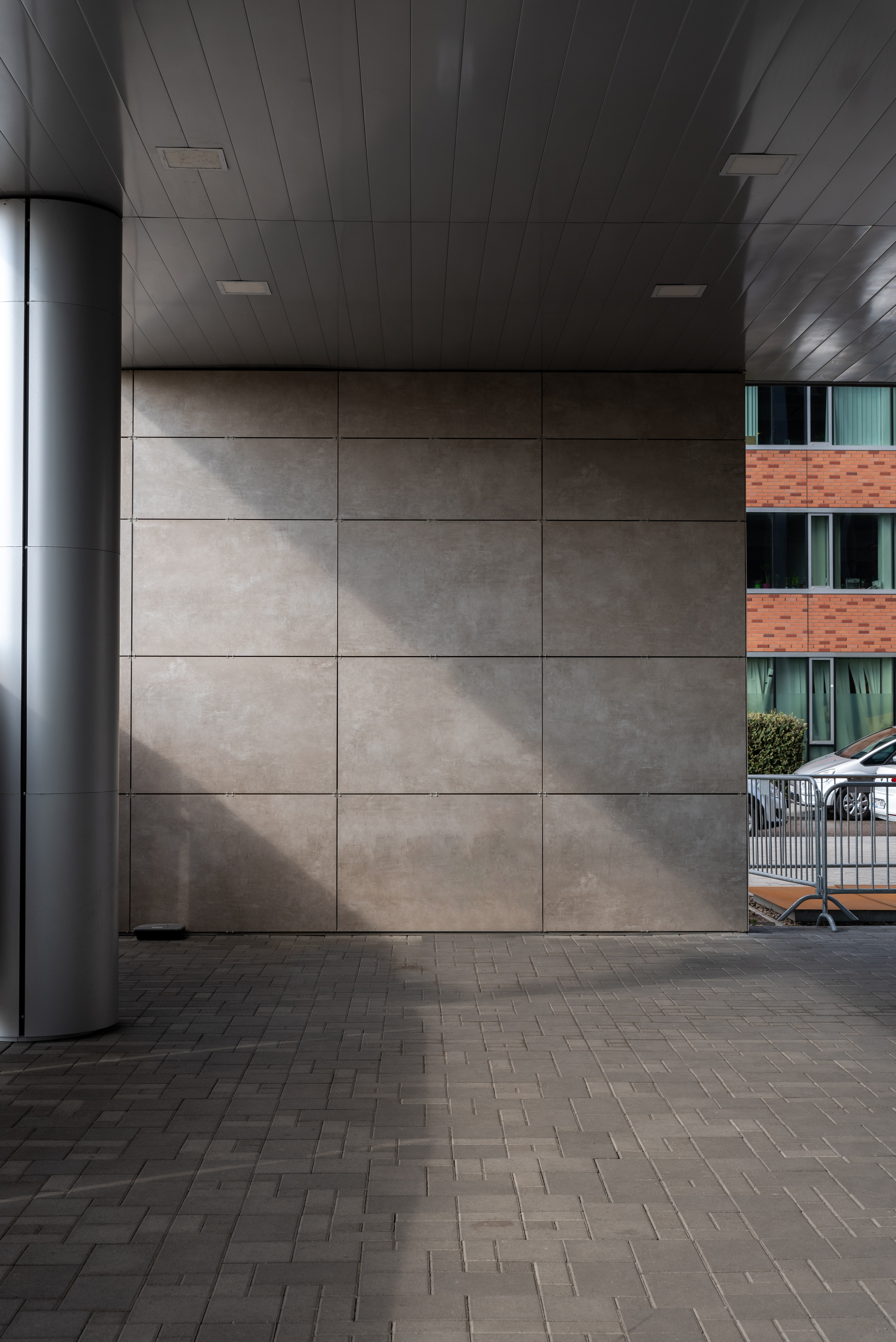Large-format concrete-look wall tiles and dark outdoor floor tiles.