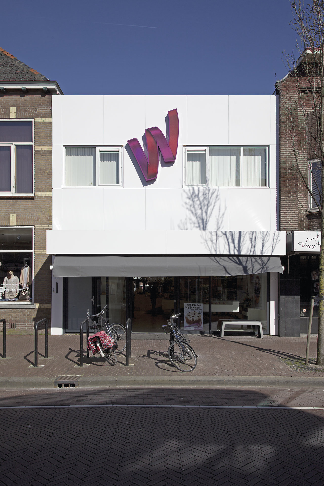Modern white shop facade with a large purple 'W' logo.