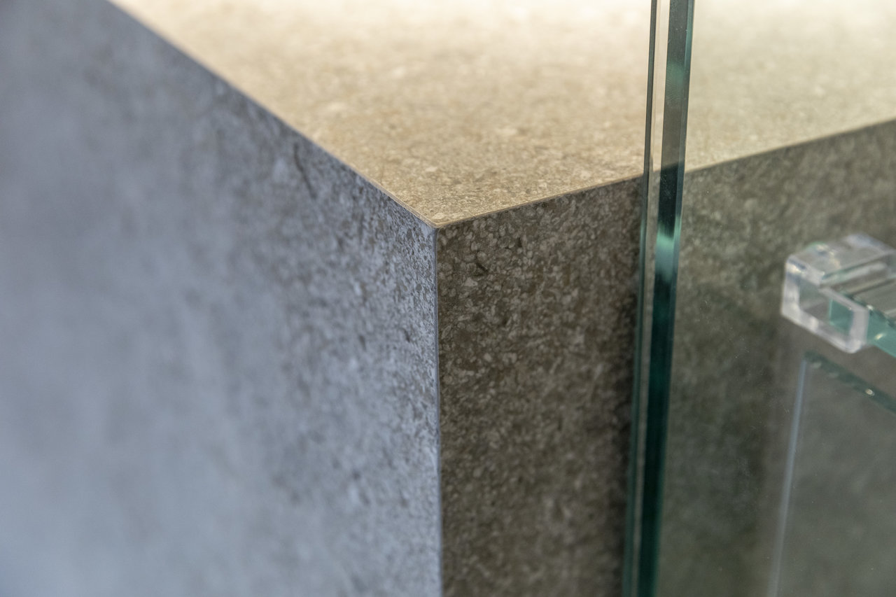 Premium grey natural stone effect tiles, precisely laid, with glass detail.