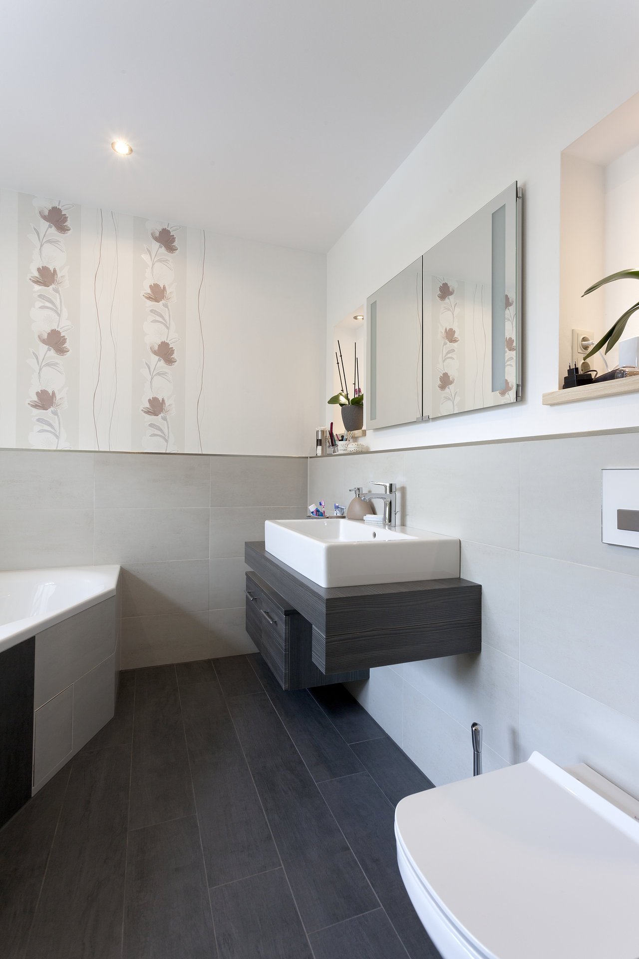 Stylish bathroom with dark floor tiles and light grey wall tiles.