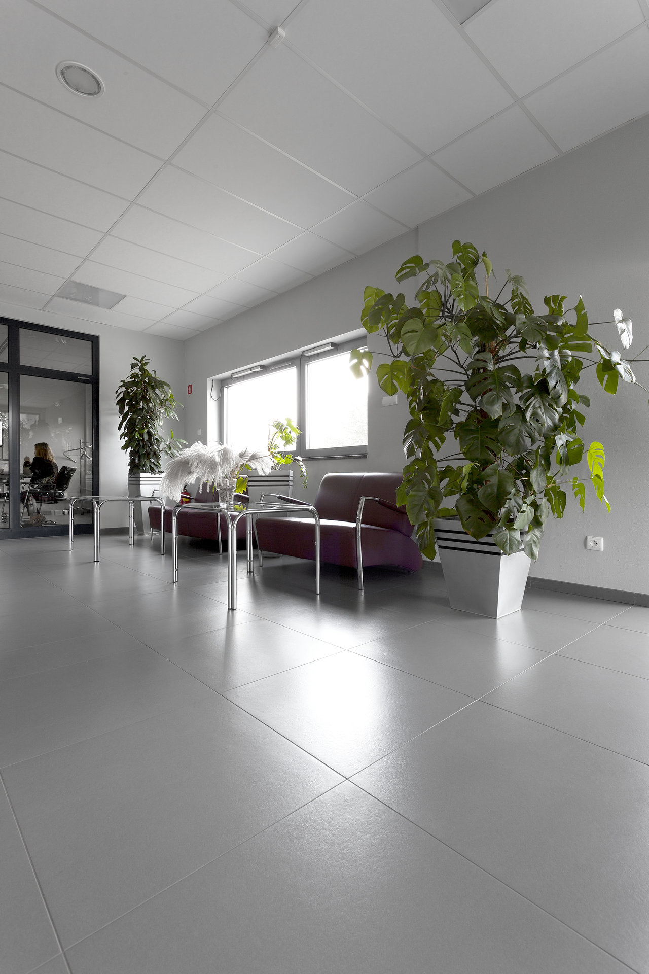 Glossy, light grey large format tiles in a modern waiting area.
