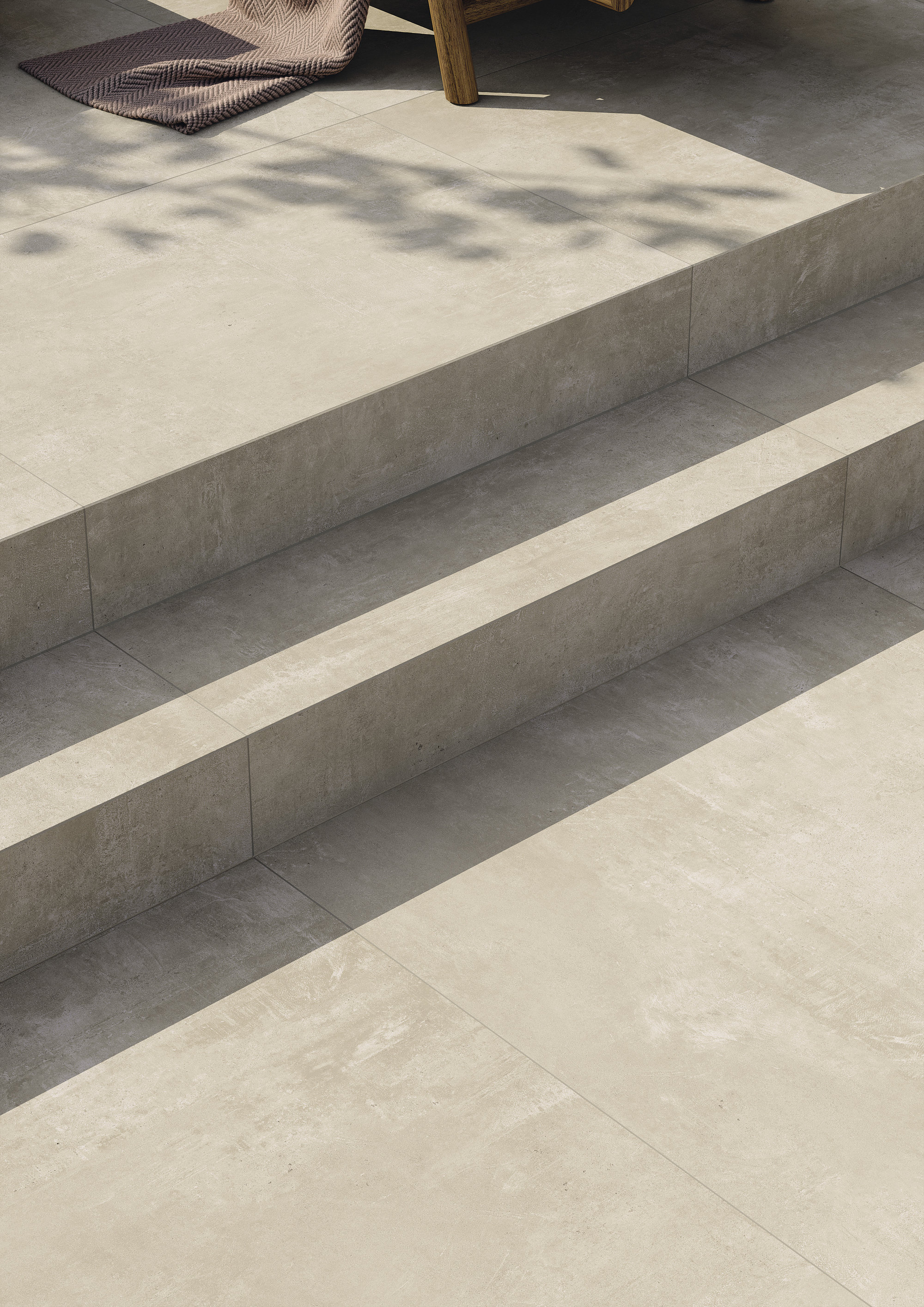 Light outdoor tiles on a sunny terrace with steps.
