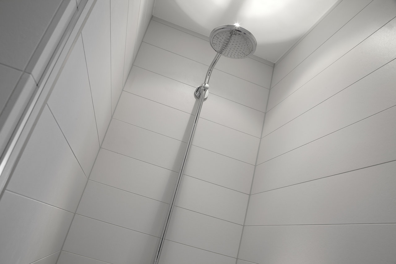 Elegant shower wall with light, horizontally laid tiles.