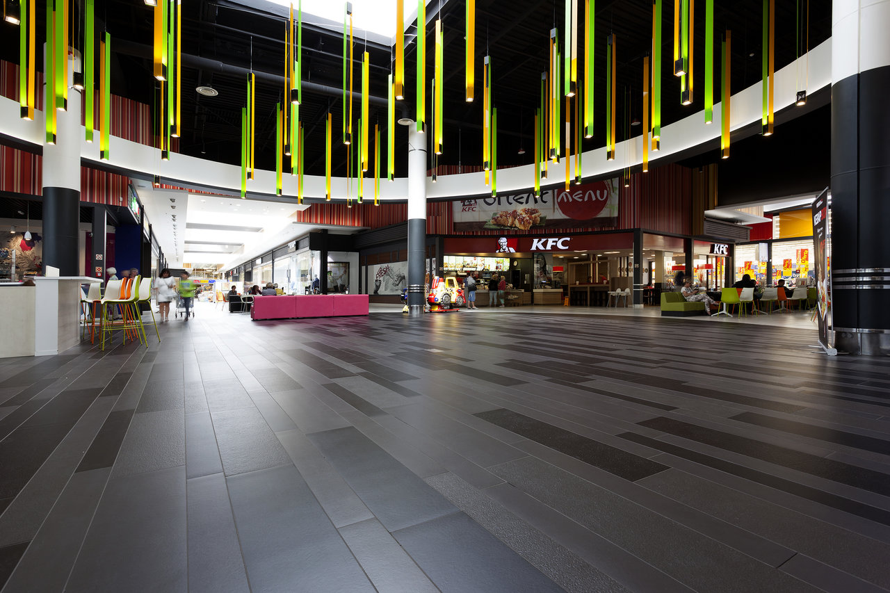 Premium dark grey floor tiles with modern pattern in a spacious hallway.