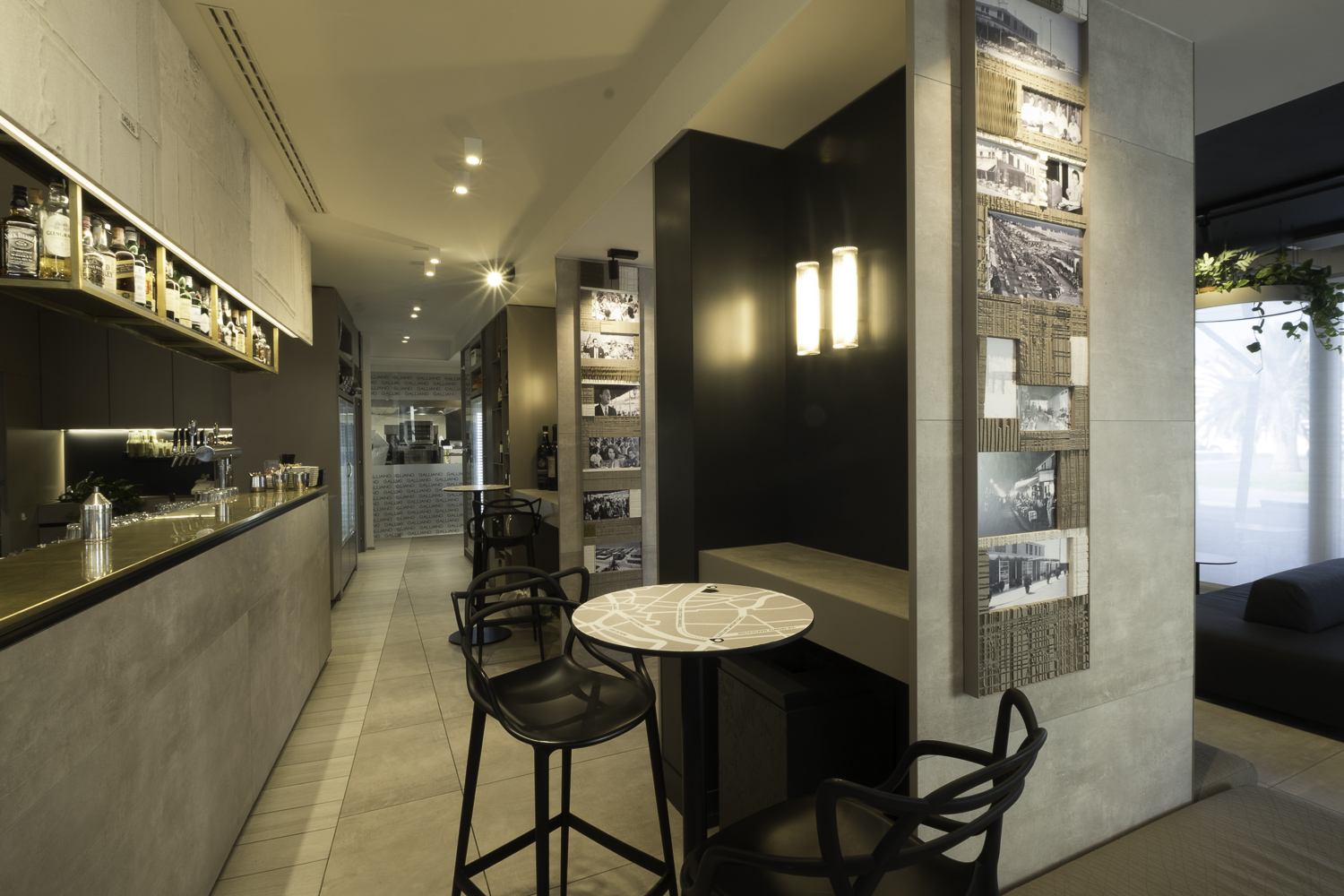 Modern bar interior with concrete-look tiles on floor, bar, and columns.