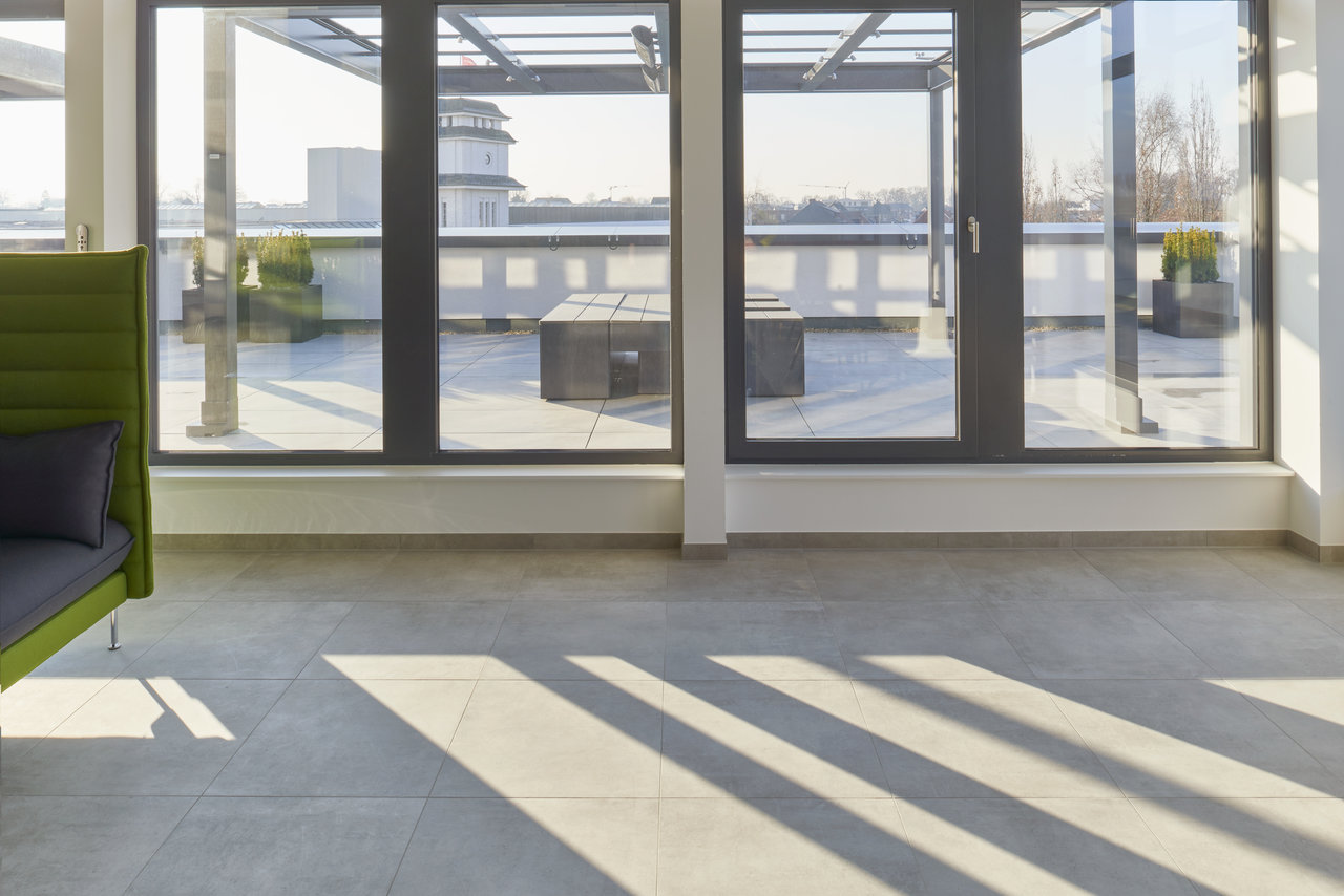 Bright, modern indoor tiles with a sunny view to a stylish roof terrace.