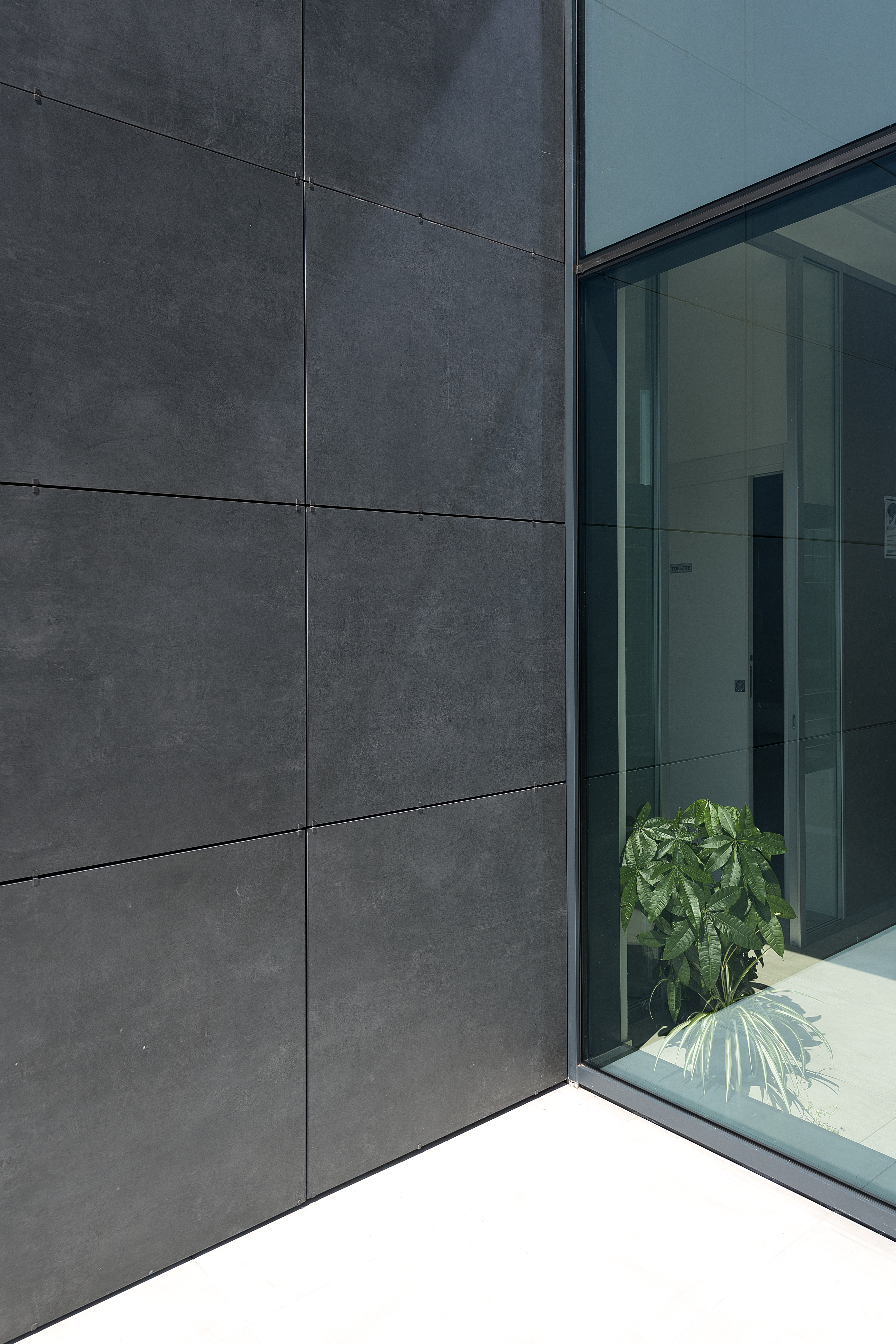 Modern building facade with anthracite outdoor tiles and glass front.