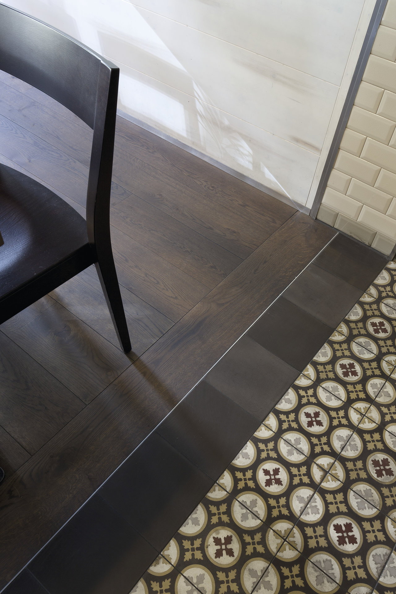 Dark wood-look and patterned decor tiles, elegantly separated by a dark trim.