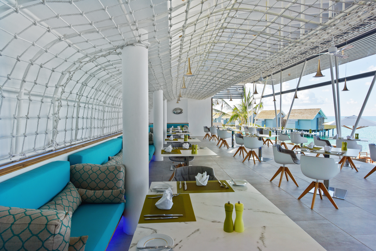 Modern restaurant with sea view and elegant floor tiles.