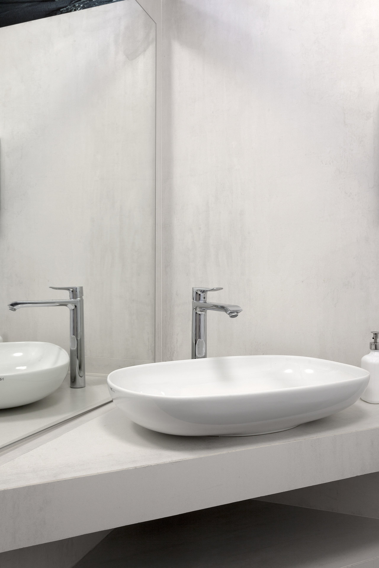 Modern bathroom with light grey wall tiles and white countertop basin.