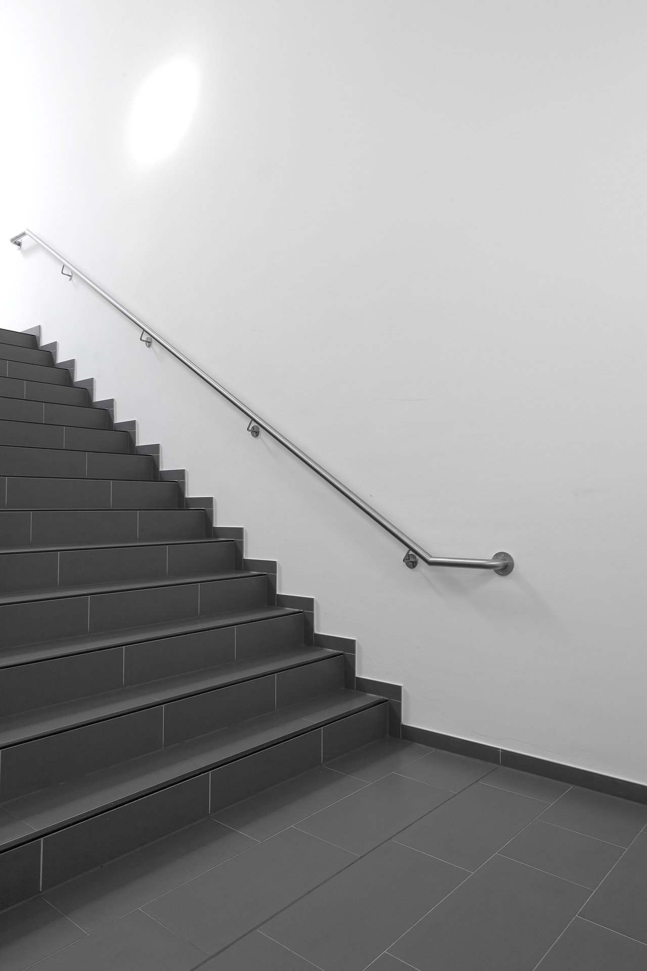 Straight stairs and floor with anthracite Porcelaingres tiles.