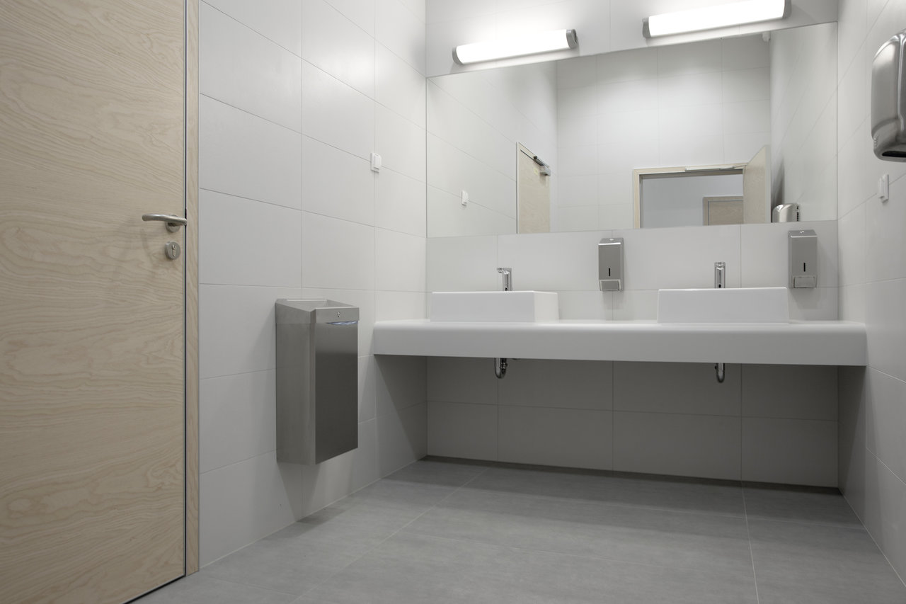 Stylish washroom with white wall tiles and grey floor tiles.