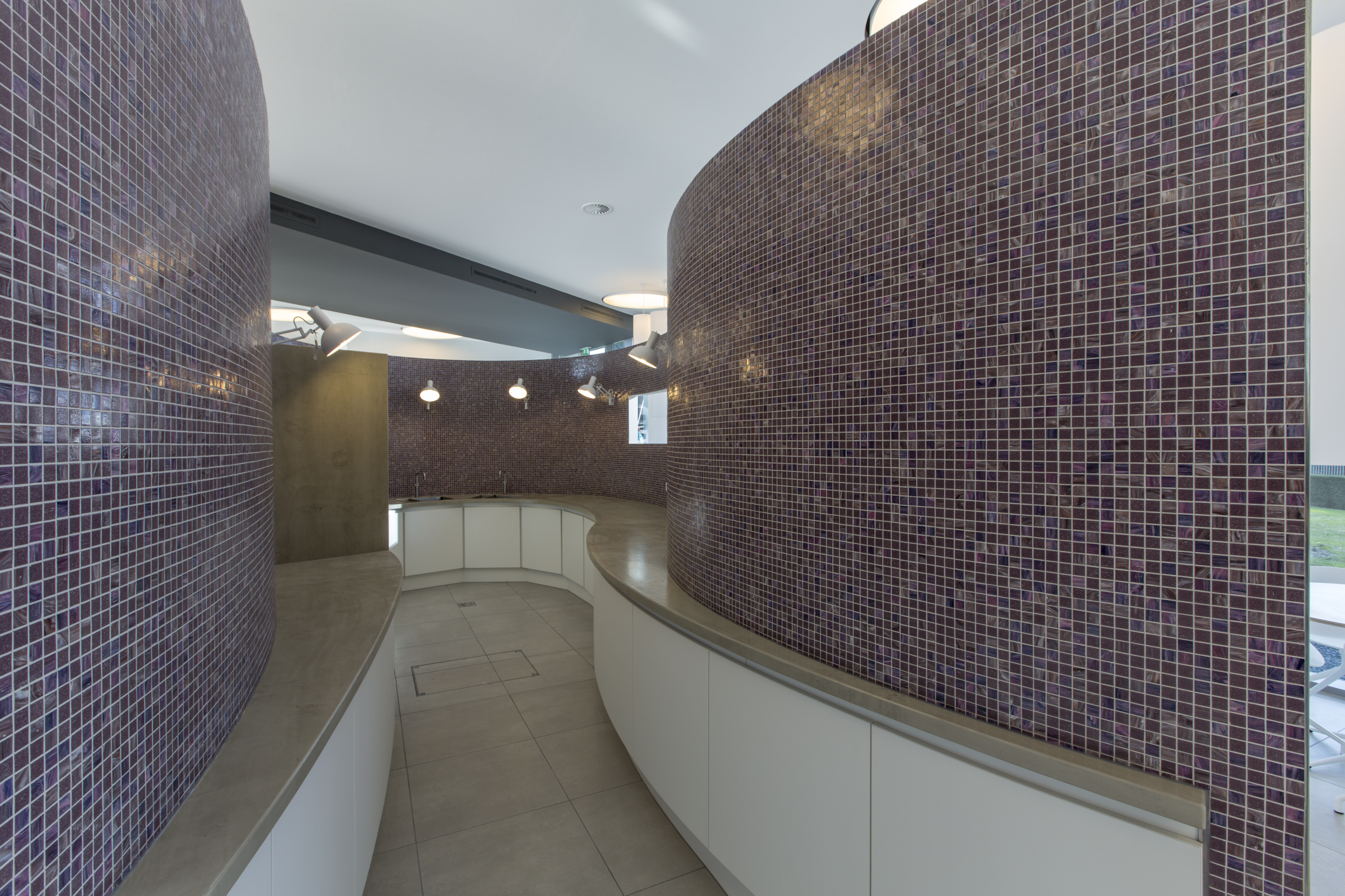 Stylish interior design with purple mosaic tiles on curved walls.