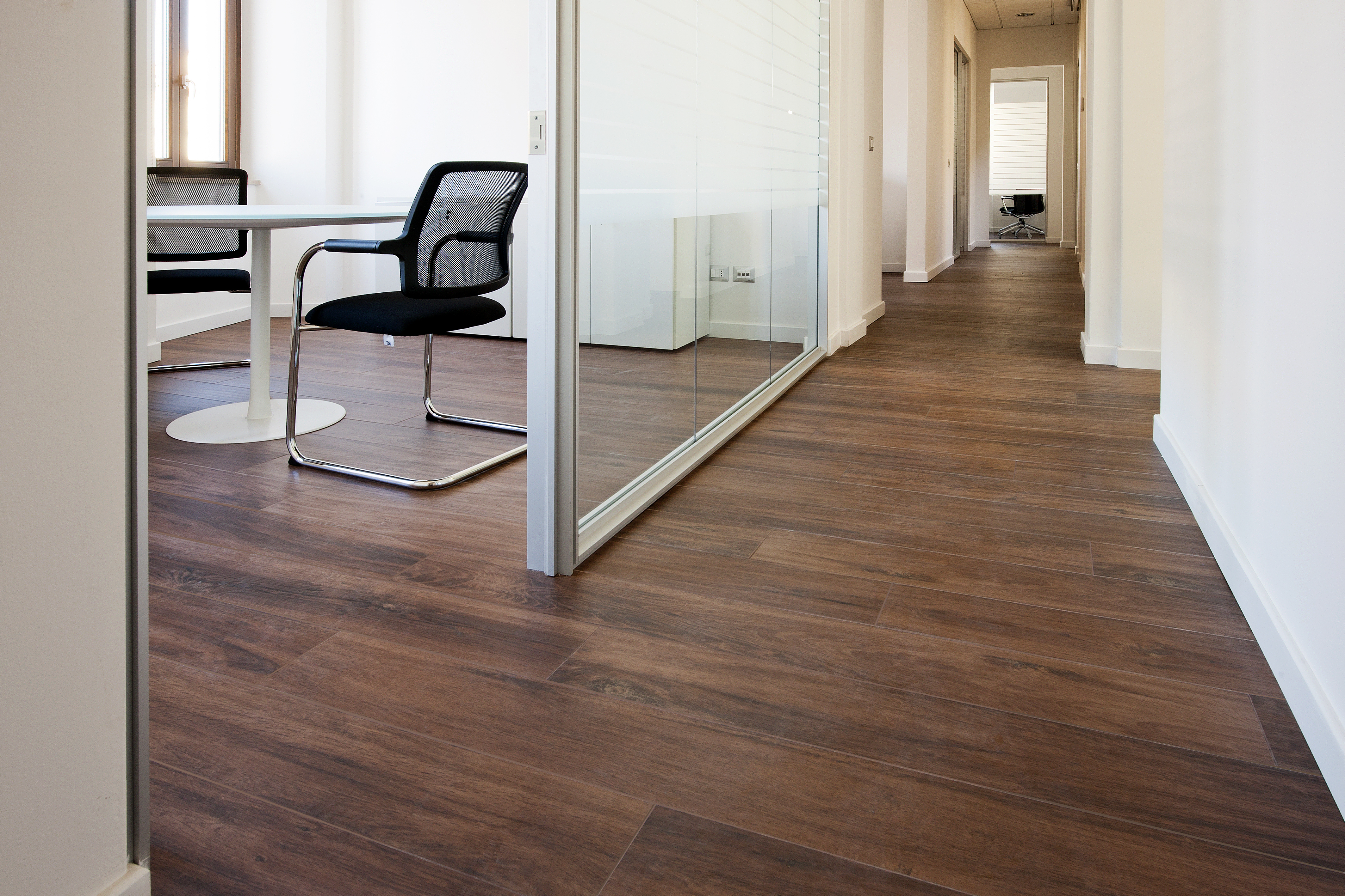Elegant dark brown wood-look tiles in the office hallway and meeting room.