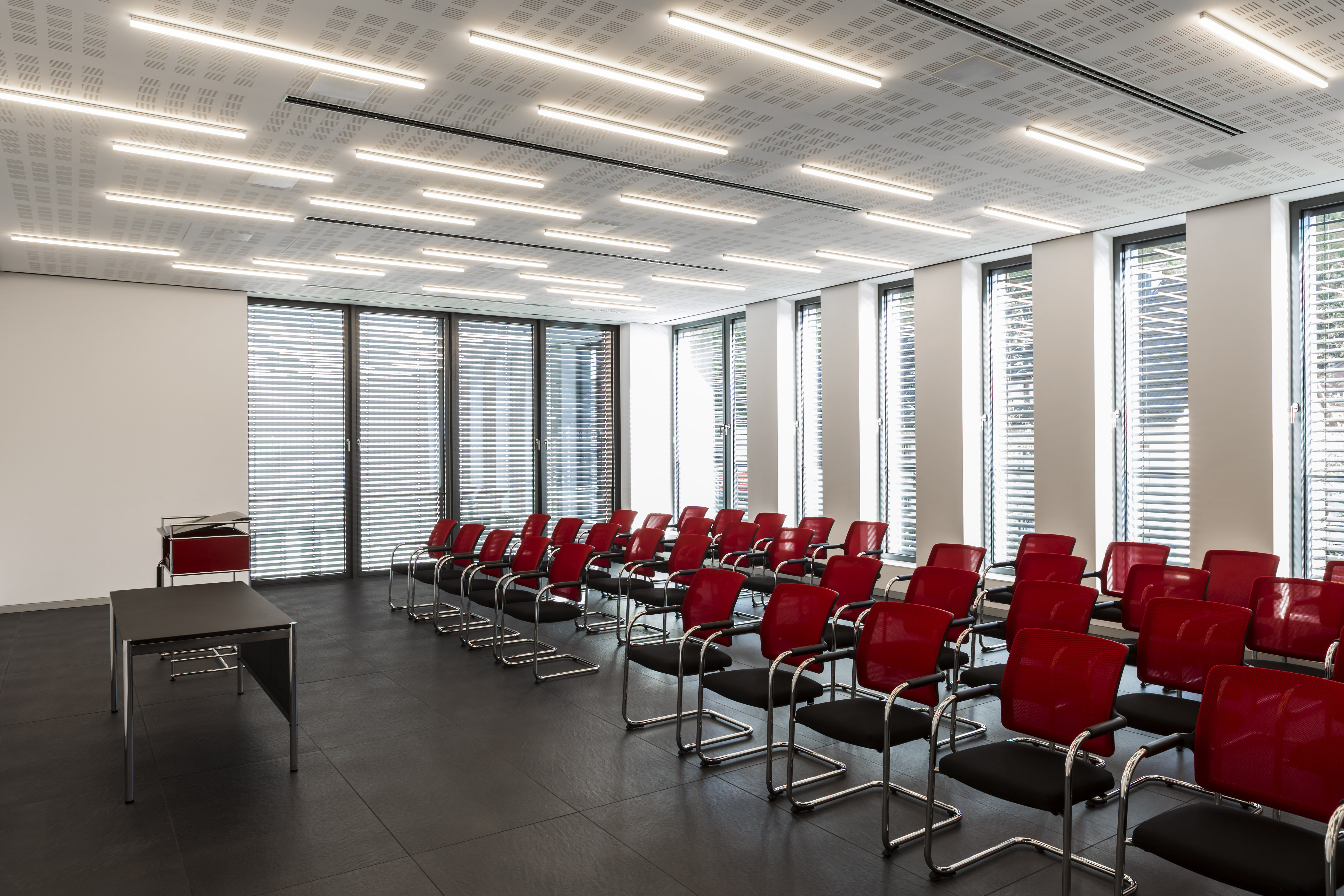 Elegant conference room with dark large-format tile flooring.