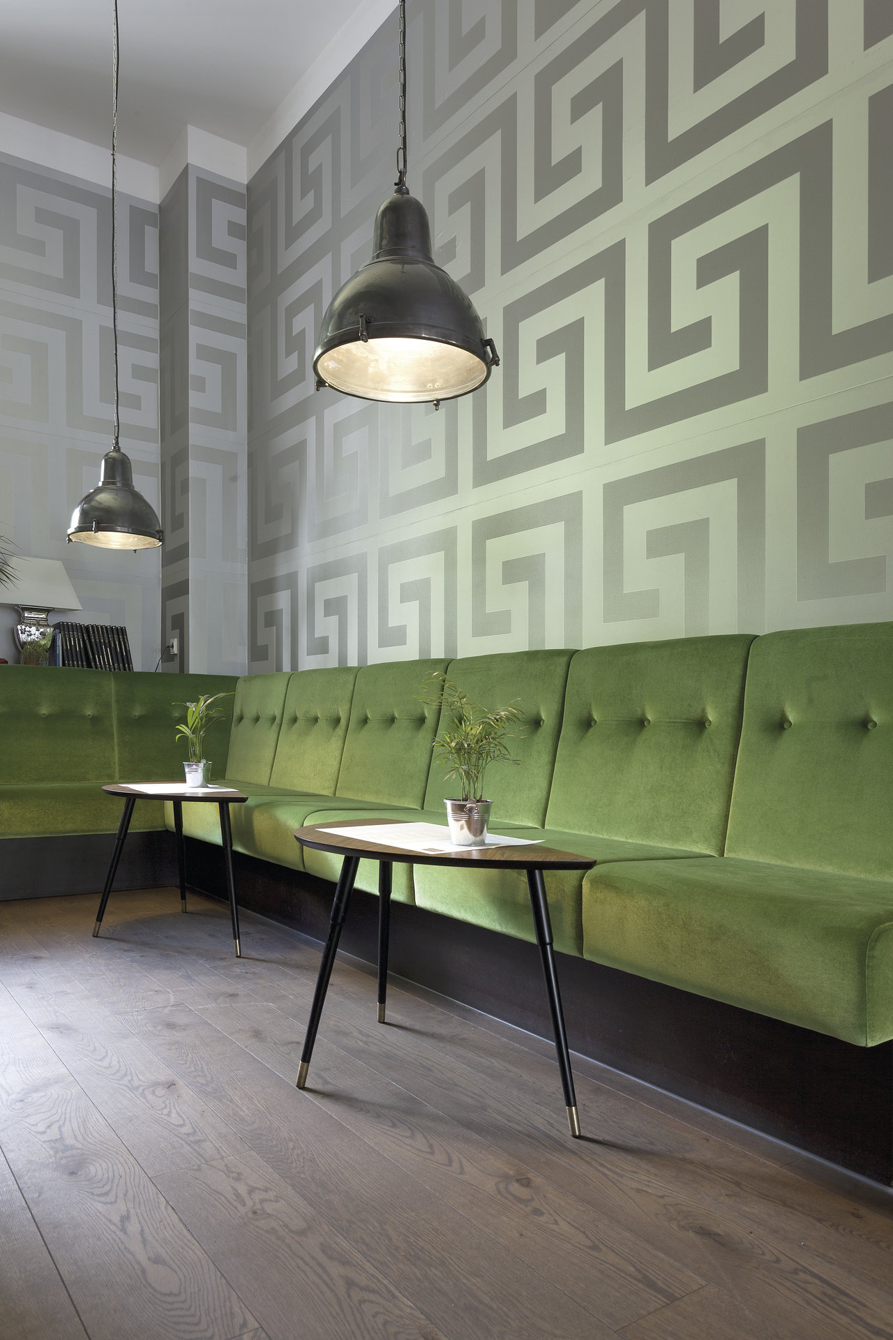 Stylish room with dark wood-look tile floor and green velvet bench.