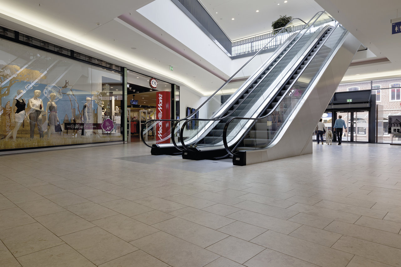 Large-format, light-coloured tiled floor in a modern shopping mall.