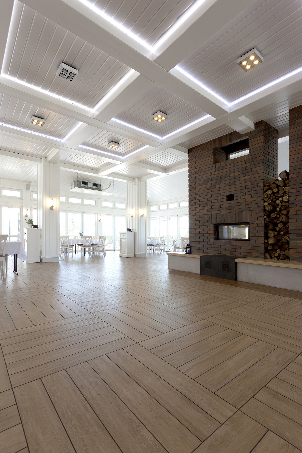 Bright room with stylish wood-effect parquet-patterned tile floor and a fireplace.