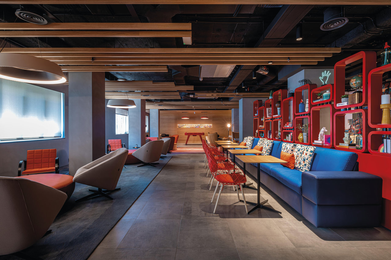 Modern lounge area with elegant grey floor tiles and colourful decor.
