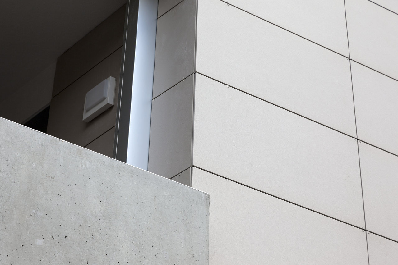 Light, large-format tiles on a modern building facade.