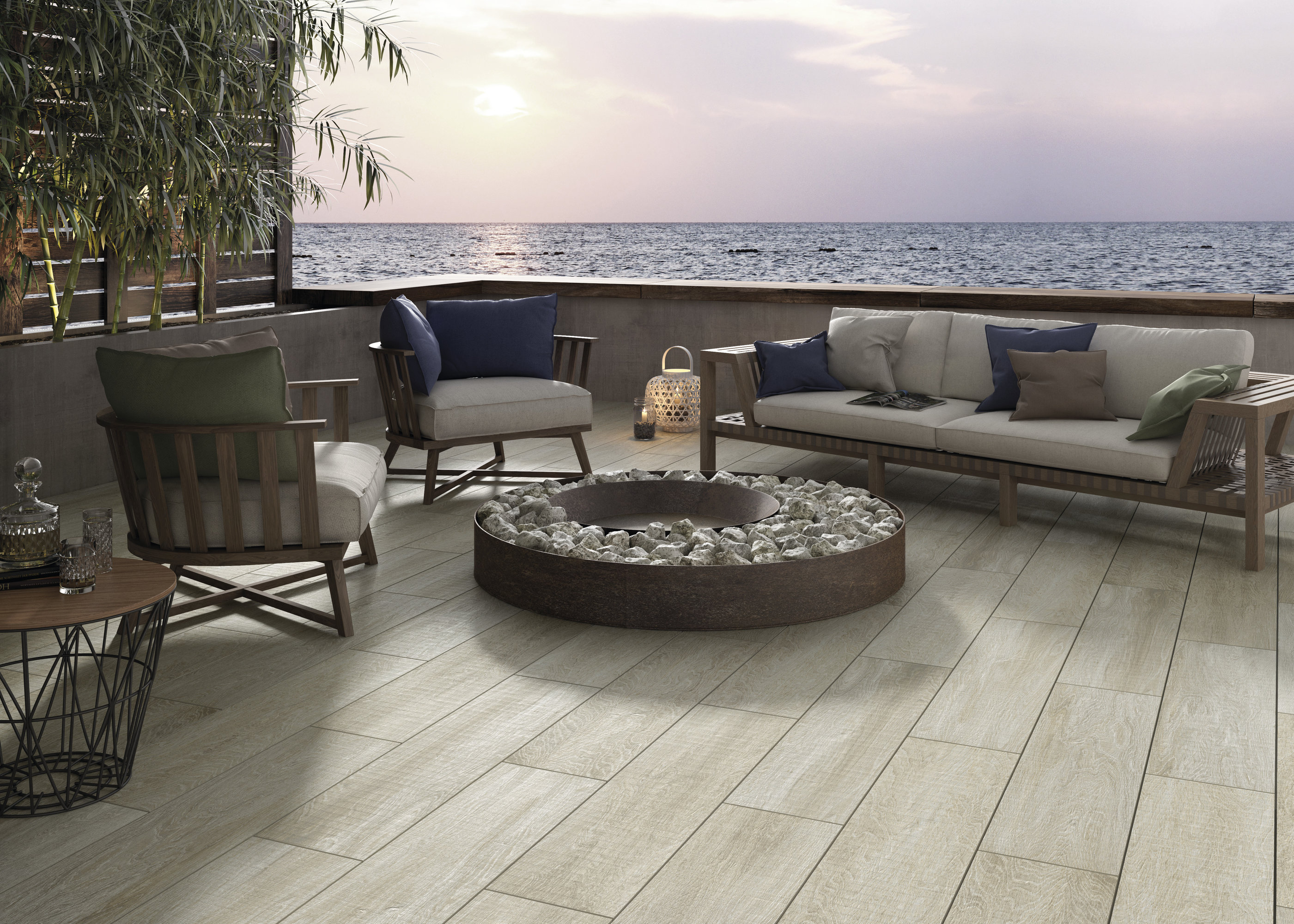 Terrace with light wood-look tiles, lounge sofa, and sea view at sunset.