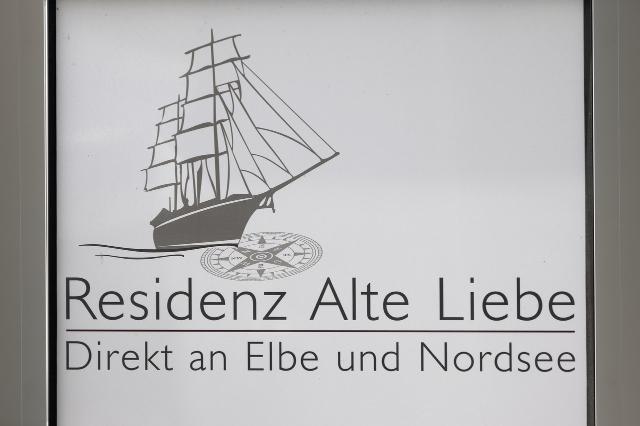 Sign 'Residenz Alte Liebe' with sailing ship, compass rose, and 'Directly on Elbe and North Sea'.