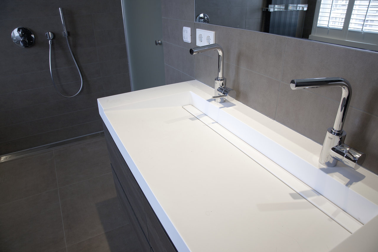 Modern bathroom with double vanity and high-quality grey tiles.